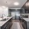 Kitchen With Stainless Steel Appliances, Dark Wood Cabinetry, Sleek White Countertops and Modern Light Fixtures